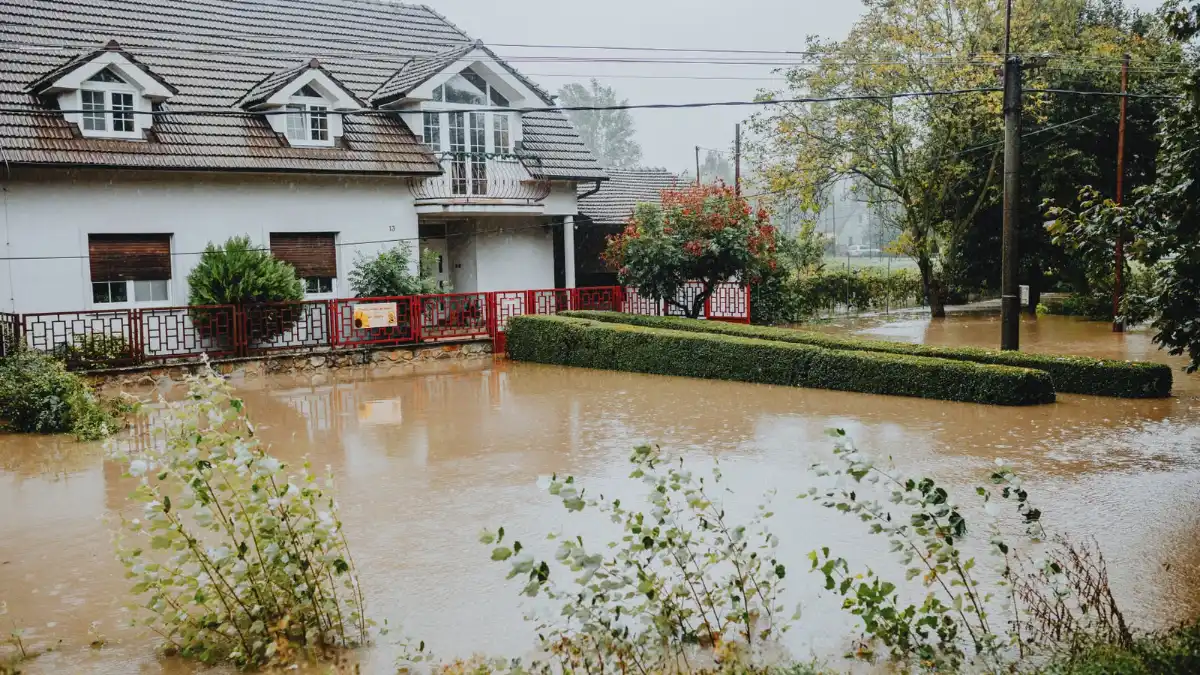 Floodwater covering the yard and driveway of a two-story house